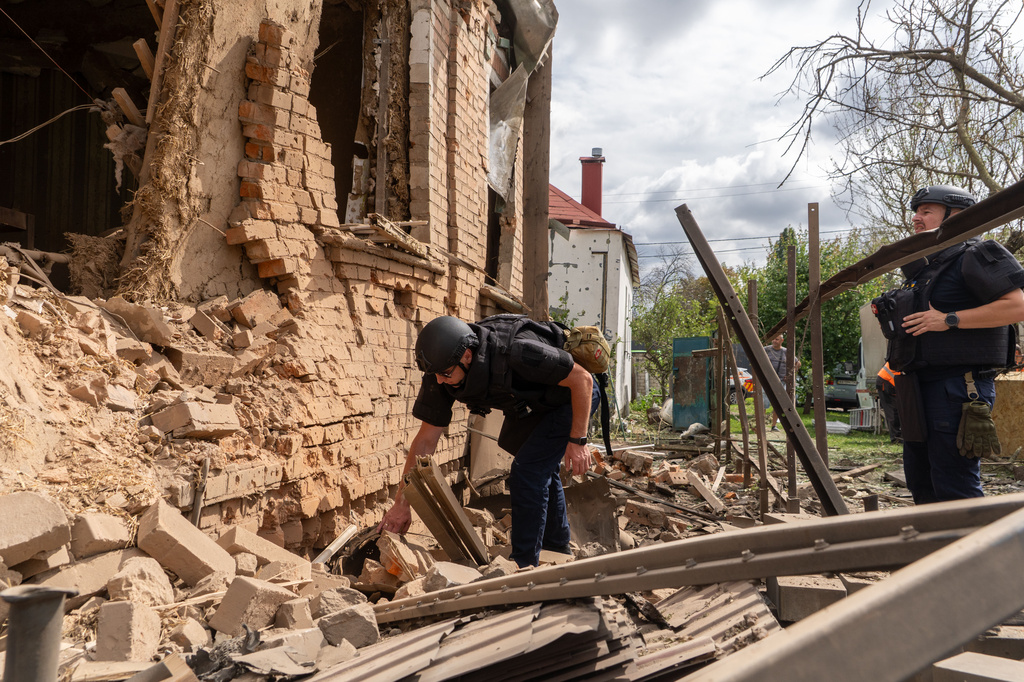 Rescuers search through the rubble of a private house destroyed by a Russian drone in Kharkiv, Ukraine, Sunday, July 26, 2026. (AP Photo/Andrii Marienko)