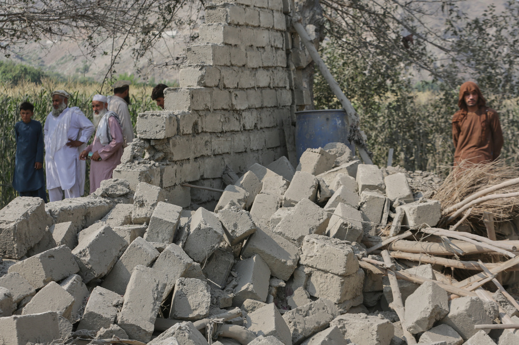 Residents stand near a collapsed wall of a house damaged in a strike in Patan village, Kunar province, eastern Afghanistan, Monday, Sept. 21, 2026. (AP Photo/Shafiullah Kakar)