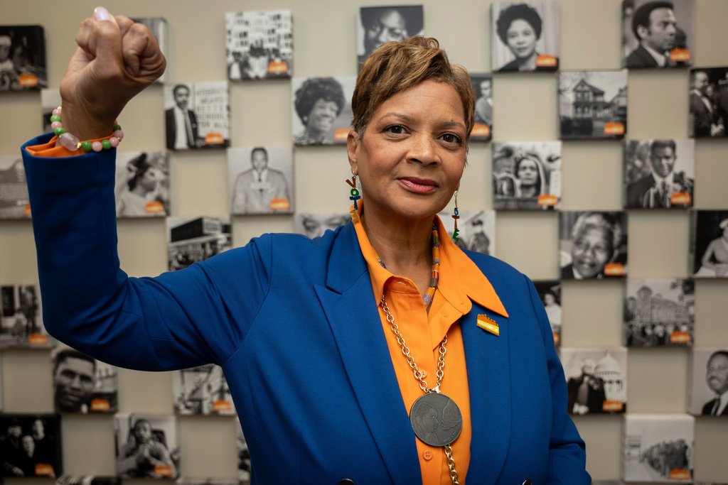 Deborah Scott, CEO of Georgia Stand-Up, raises her fist while standing in front of a wall honoring unsung heroes of the civil rights movement at The Movement Center, in Atlanta, Sunday, Nov. 30, 2025. (AP Photo/Olivia Bowdoin)