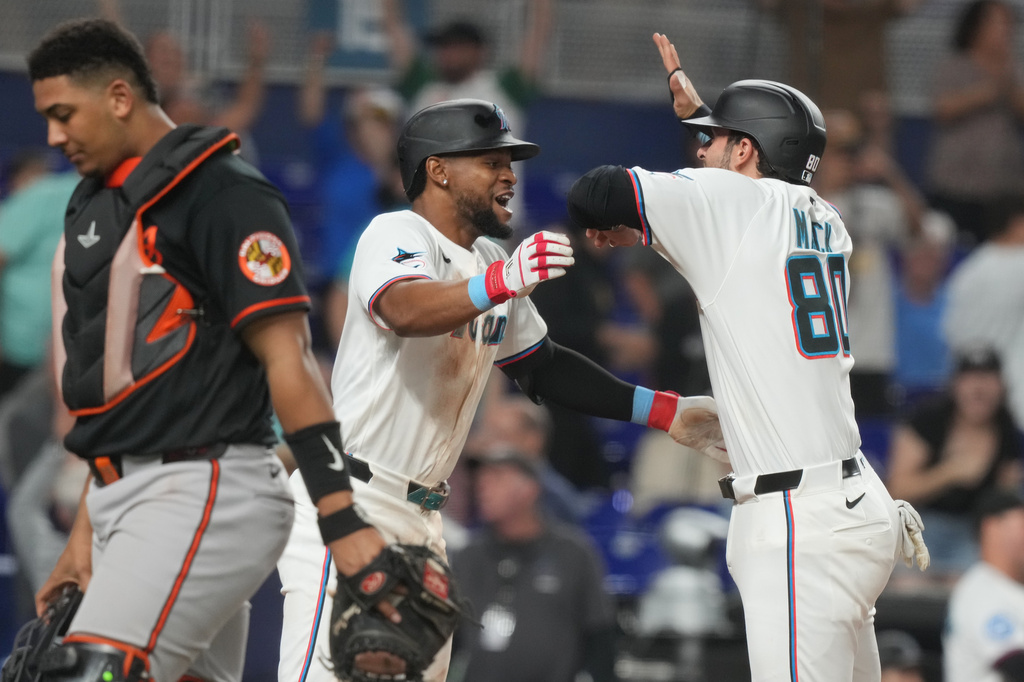 Miami Marlins' Joe Mack (80) and Otto Lopez (6) celebrate after defeating the Baltimore Orioles in the ninth inning of a baseball game Thursday, May 7, 2026, in Miami. (AP Photo/Marta Lavandier)