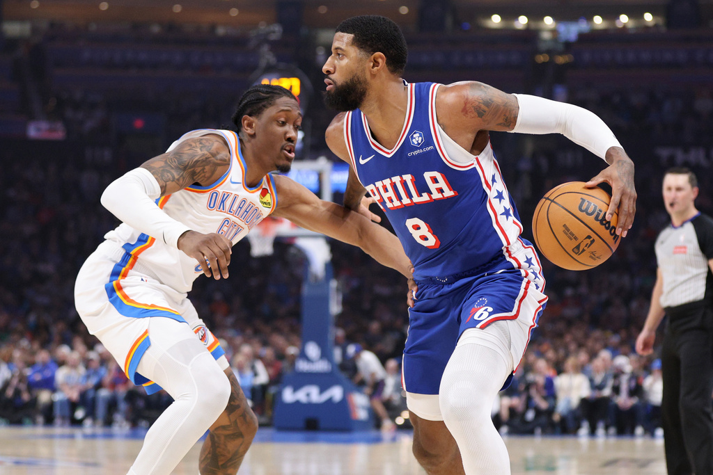 Philadelphia 76ers forward Paul George (8) handles the ball against Oklahoma City Thunder guard Jalen Williams, left, during the first half of an NBA basketball game, Sunday, Dec. 28, 2025, in Oklahoma City. (AP Photo/Nate Billings)