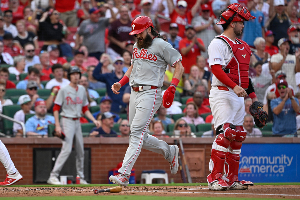 Philadelphia Phillies' Brandon Marsh, center, crosses home plate to score behind St. Louis Cardinals catcher Jimmy Crooks, right, in the second inning of a baseball game, Monday, Aug. 10, 2026, in St. Louis. (AP Photo/Joe Puetz)