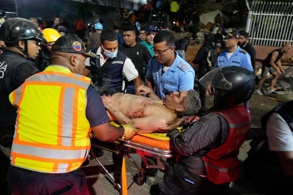 Rescue worker carry an injured man after an earthquake in Caracas, Venezuela, Wednesday, June 24, 2026. (AP Photo/Ariana Cubillos)