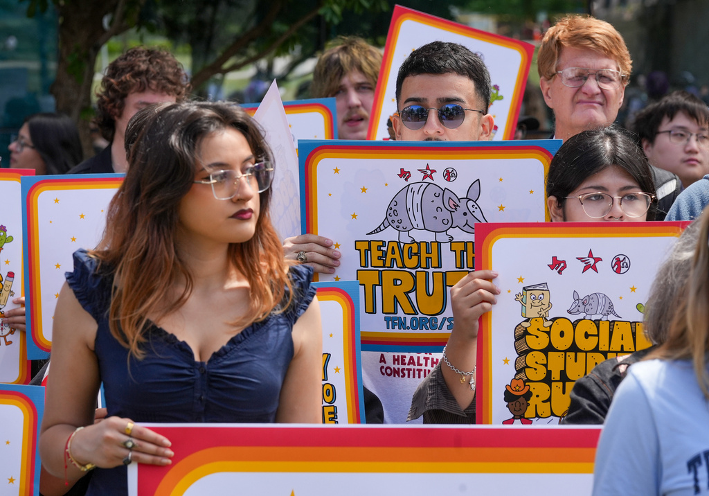People hold signs reading "Teach the Truth" during a rally on the Capitol Mall outside the Barbara Jordan State Office Building, where the State Board of Education meets, Tuesday, April 7, 2026, in Austin, Texas. (Jay Janner/Austin American-Statesman via AP)