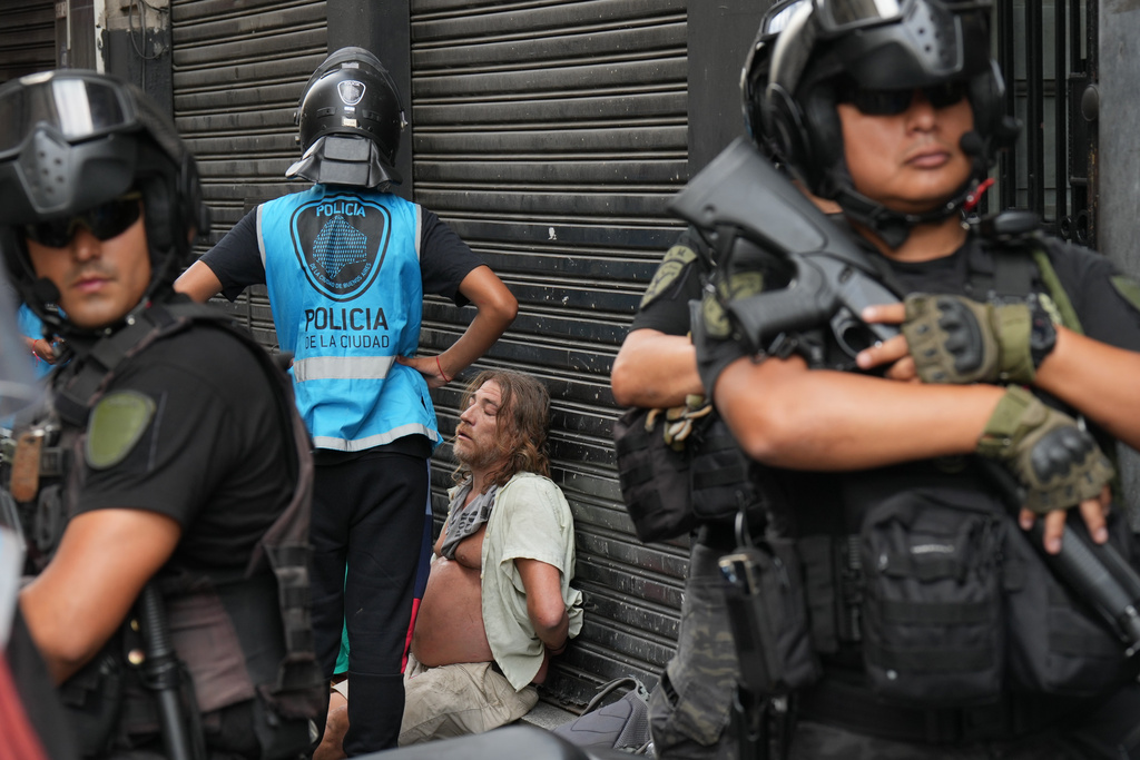 Police stand around a protester detained during a march by trade unions and opposition groups against a labor reform bill proposed by President Javier Milei's government in Buenos Aires, Argentina, Wednesday, Feb. 11, 2026.(AP Photo/Gustavo Garello)