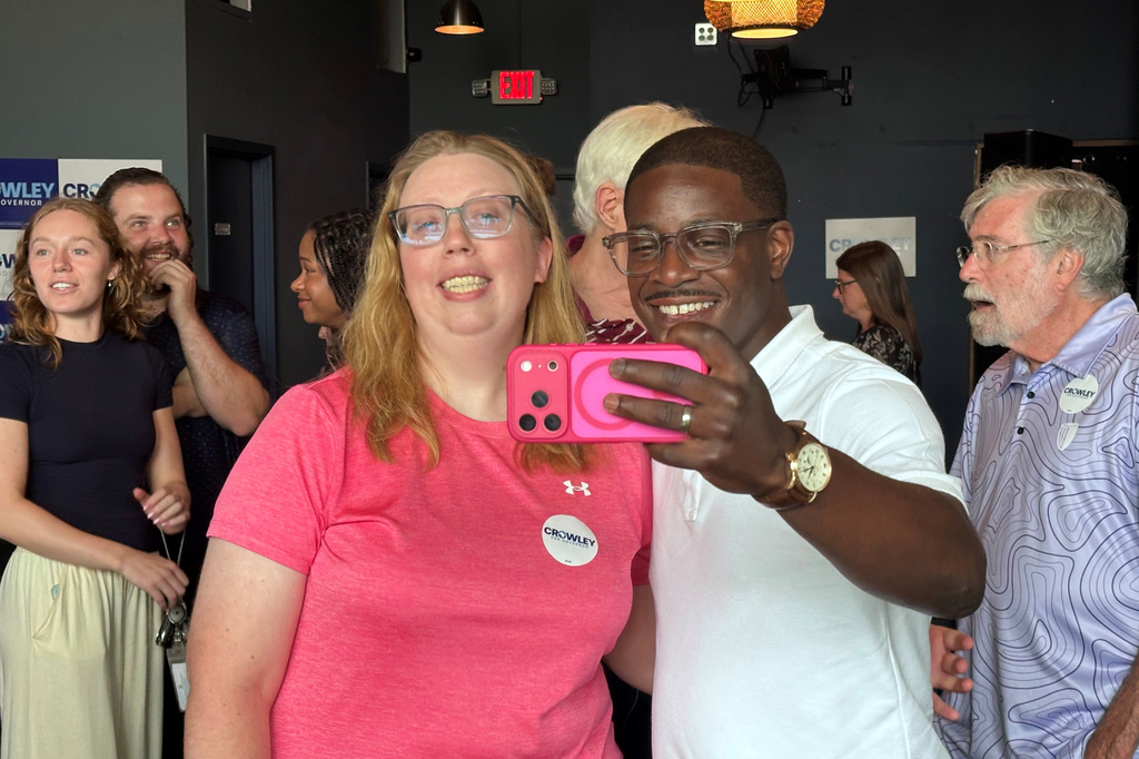 David Crowley, Democratic candidate for Wisconsin governor, takes a selfie photo with supporter Abigail Tessmann during a campaign stop Wednesday, Aug. 5, 2026, in Madison, Wis. (AP Photo/Scott Bauer)