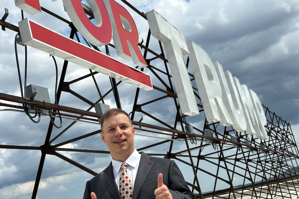 Anthony Constantino, a Republican candidate for Congress, stands next to the large "Vote for Trump" sign on the roof of his printing company, Sticker Mule, in Amsterdam, New York, Thursday, April 16, 2026. (AP Photo/Michael Hill)