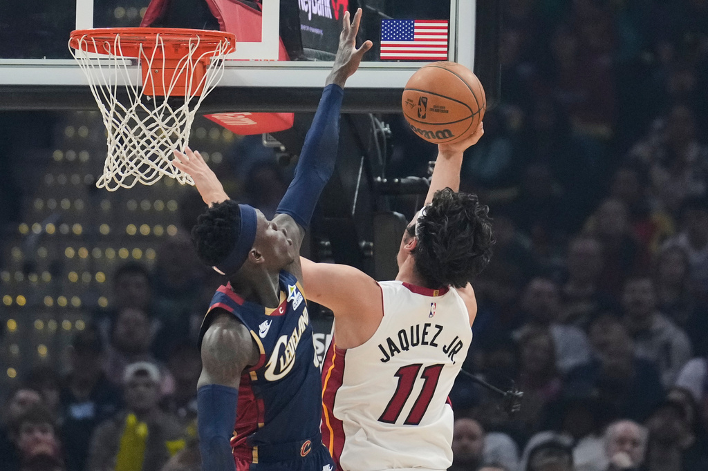 Miami Heat forward Jaime Jaquez Jr. (11) shoots as Cleveland Cavaliers guard Dennis Schroder, left, defends in the first half of an NBA basketball game in Cleveland, Friday, March 27, 2026. (AP Photo/Sue Ogrocki)