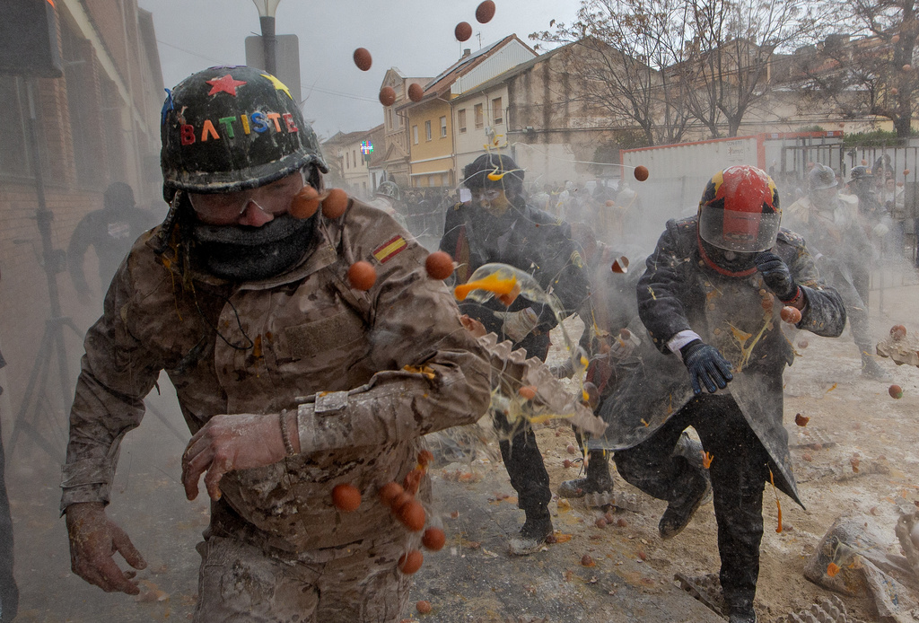 Revellers take part in the Els Enfarinats festival, a battle using flour, eggs and firecrackers, in the town of Ibi near Alicante, Spain, Sunday Dec. 28, 2025. (AP Photo/Alberto Saiz)