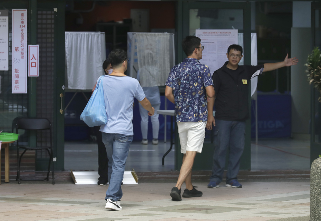 People arrive at a polling station in Taipei, Taiwan, Saturday, Aug. 23, 2025, during the vote which includes a referendum on restarting the Maanshan nuclear power plant. (AP Photo/Chiang Ying-ying)