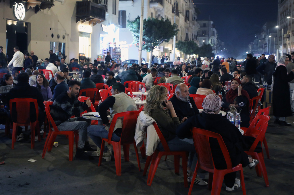 People crowd at a coffee shop to catch time before earlier closing hours applied, as part of a series of measures the government has taken to mitigate the fallout of the U.S. and Israeli war against Iran, in Cairo, Egypt, Saturday, March 28, 2026. (AP Photo/Khaled Elfiqi)