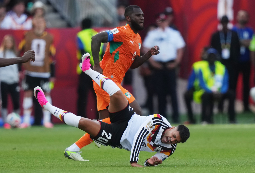 Germany's Nadiem Amiri (20) falls as Ivory Coast's Franck Kessie (back) looks on during the World Cup Group E soccer match between Germany and Ivory Coast in Toronto, Saturday, June 20, 2026. (Nathan Dennette/The Canadian Press via AP)