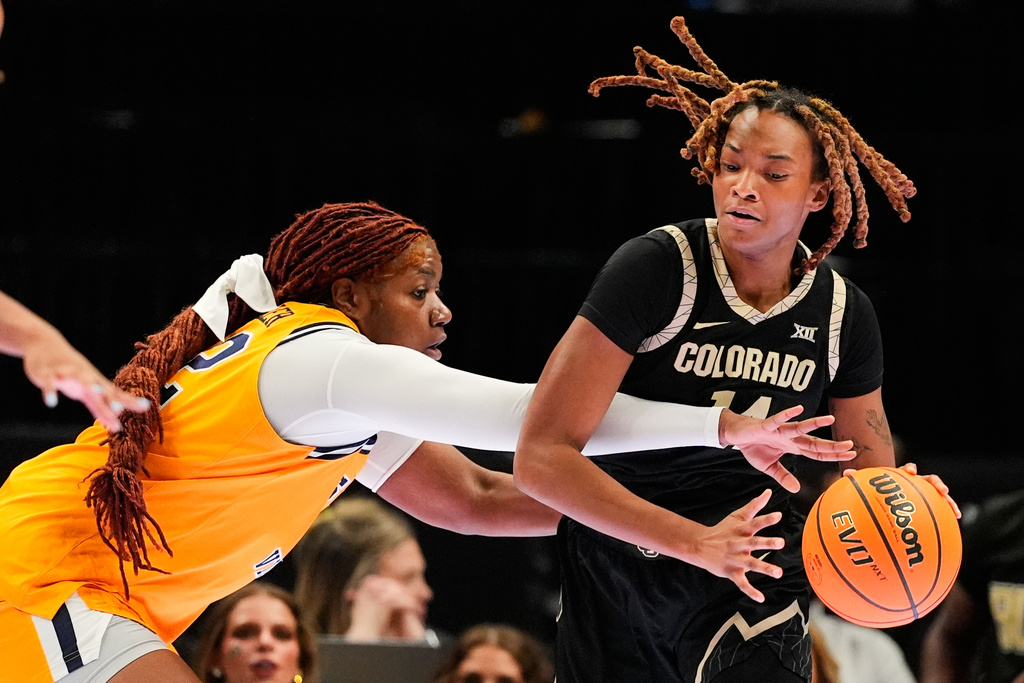 West Virginia's Kierra Wheeler, left, tries to steal the ball away from Colorado's Jade Masogayo, right, during second half of an NCAA college basketball game in the semifinals of the Big 12 Conference tournament Saturday, March 7, 2026, in Kansas City, Mo. (AP Photo/Charlie Riedel)