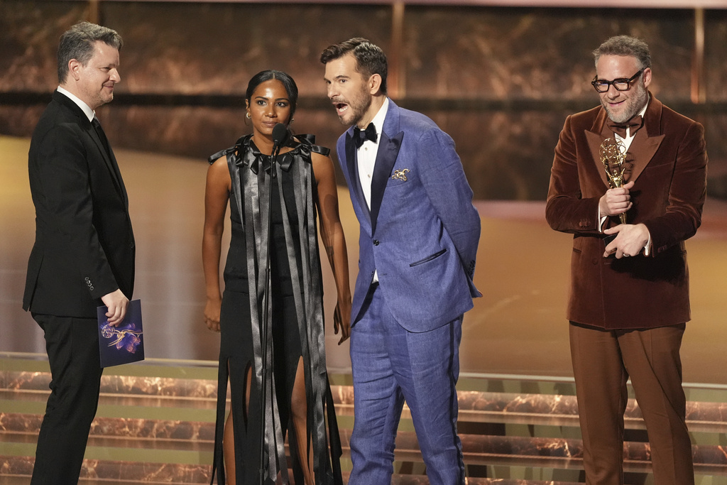 Alex Gregory, from left Frida Perez, Peter Huyck, and Seth Rogen, and accept the award for outstanding writing for a comedy series for "The Studio" during the 77th Primetime Emmy Awards on Sunday, Sept. 14, 2025, at the Peacock Theater in Los Angeles. (AP Photo/Chris Pizzello)
