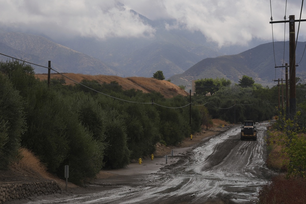 Workers clean up the damage caused by mudslides after storms in Yucaipa, Calif., Friday, Sept. 19, 2025. (AP Photo/Damian Dovarganes)
