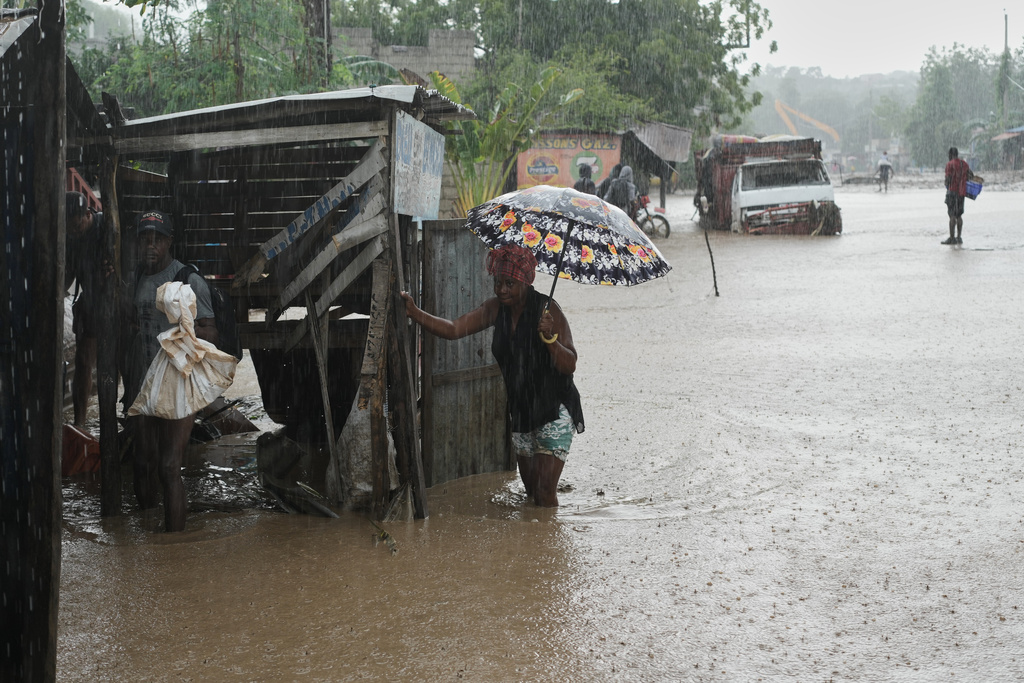 Residents wade through a flooded street in the aftermath of Hurricane Melissa in Petit-Goave, Haiti, Thursday, Oct. 30, 2025. (AP Photo/Odelyn Joseph),