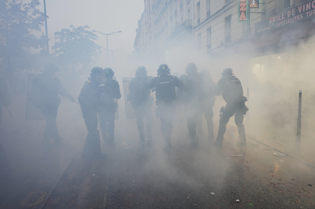 Police officers run toward protesters during a demonstration against rising living costs in Paris, Saturday, Oct. 24, 2026. (AP Photo/Thibault Camus)