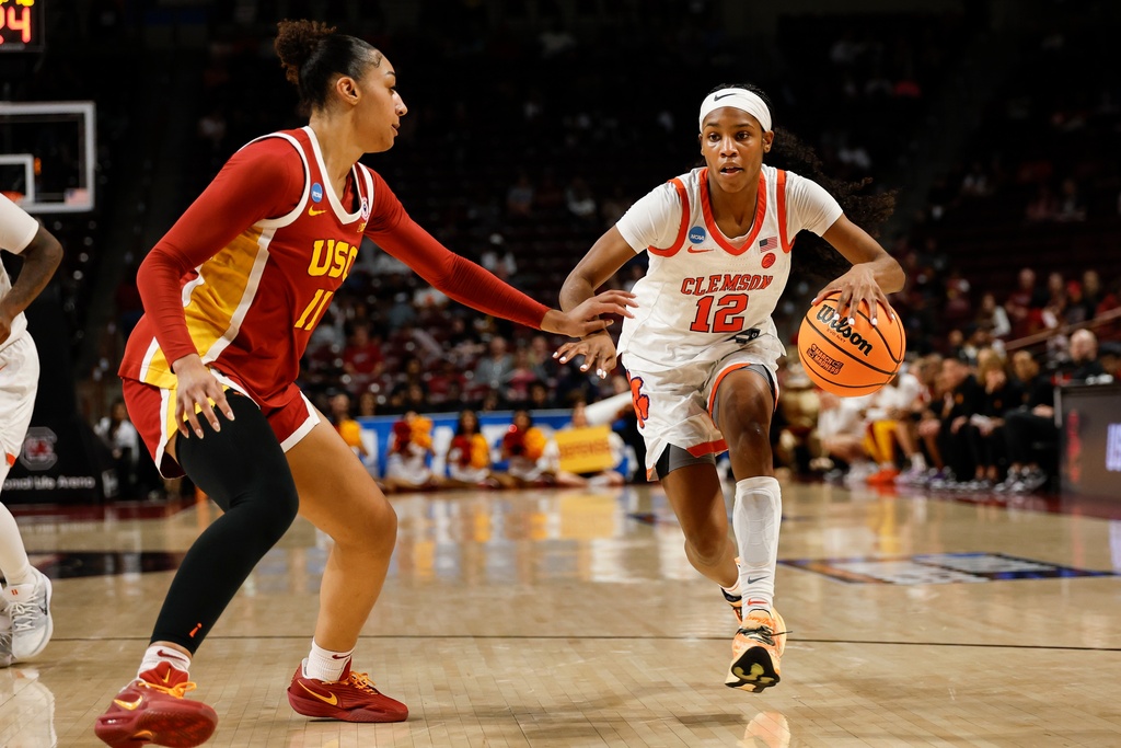 Clemson guard Mia Moore (12) drives against Southern California guard Kennedy Smith during the second half in the first round of the NCAA college basketball tournament, Saturday, March 21, 2026, in Columbia, S.C. (AP Photo/Nell Redmond)