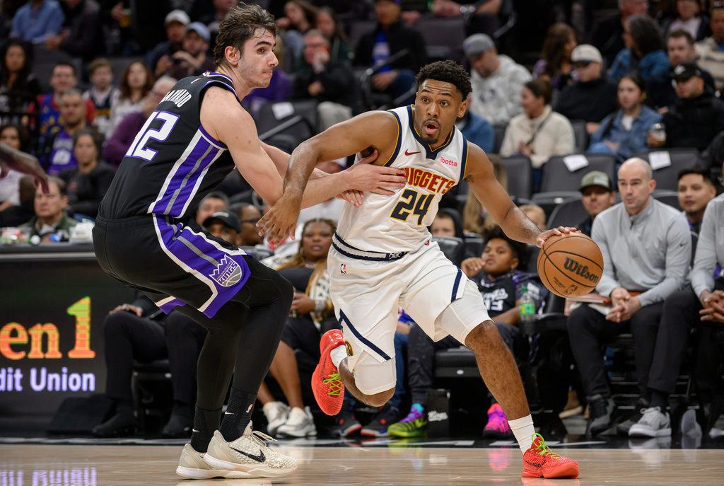 Denver Nuggets guard Jalen Pickett (24) drives around Sacramento Kings center Maxime Raynaud during the first half of an NBA basketball game in Sacramento, Calif., Thursday, Dec. 11, 2025. (AP Photo/Randall Benton)