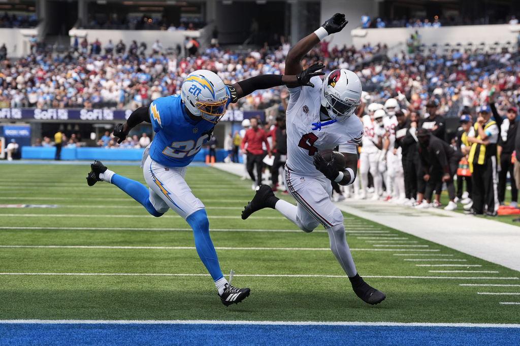 Arizona Cardinals running back Jeremiyah Love, right, runs for a touchdown against Los Angeles Chargers cornerback Cam Hart (20) during the first half of an NFL football game, Sunday, Sept. 13, 2026, in Inglewood, Calif. (AP Photo/Gregory Bull)