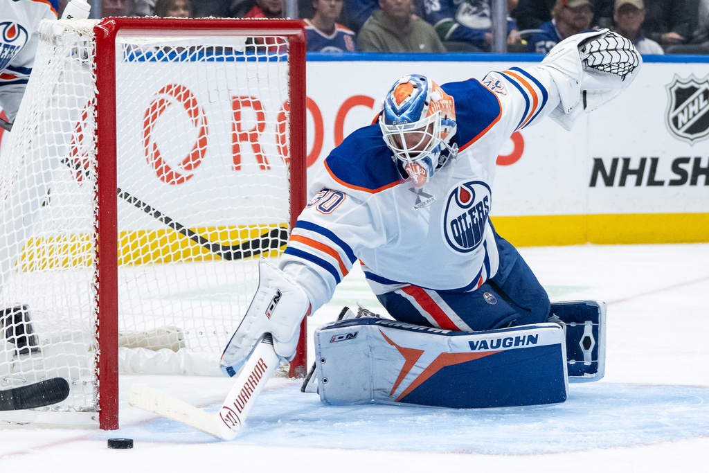 Edmonton Oilers goaltender Calvin Pickard (30) stops the puck against the Vancouver Canucks during third period NHL hockey action in Vancouver, British Columbia, Sunday, Oct. 26, 2025. (Ethan Cairns/The Canadian Press via AP)