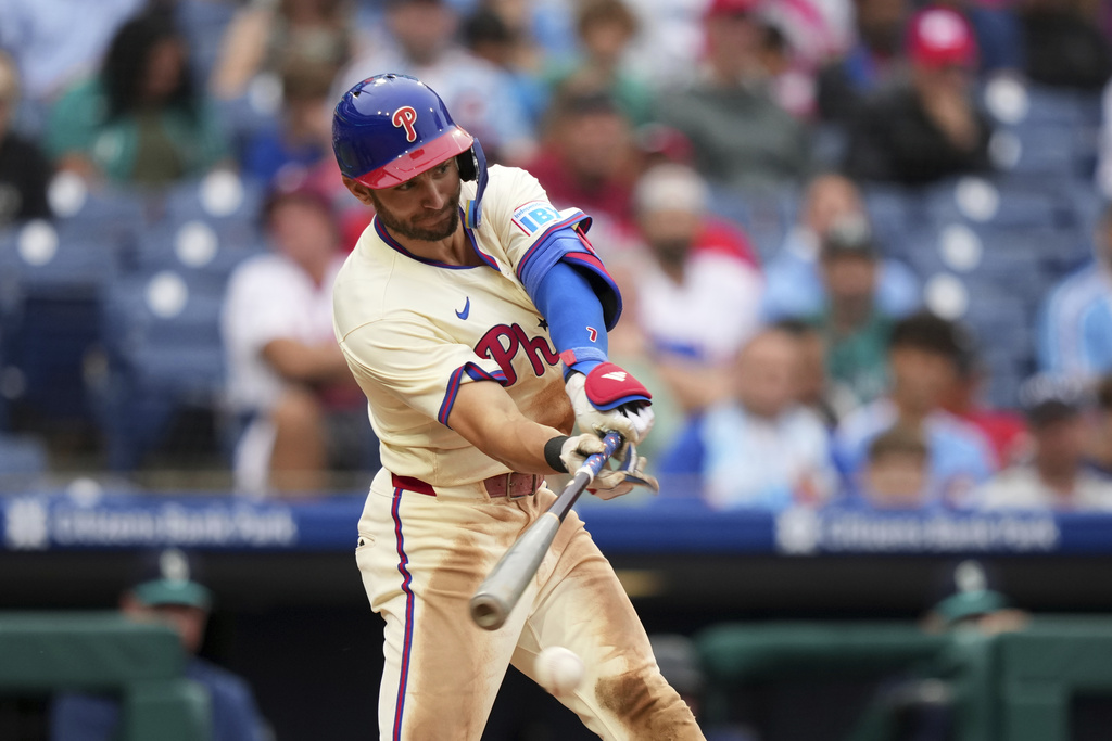 Philadelphia Phillies' Trea Turner hits a run-scoring single against Seattle Mariners pitcher Sauryn Lao during the eighth inning of a baseball game Wednesday, Aug. 20, 2025, in Philadelphia. (AP Photo/Matt Slocum)