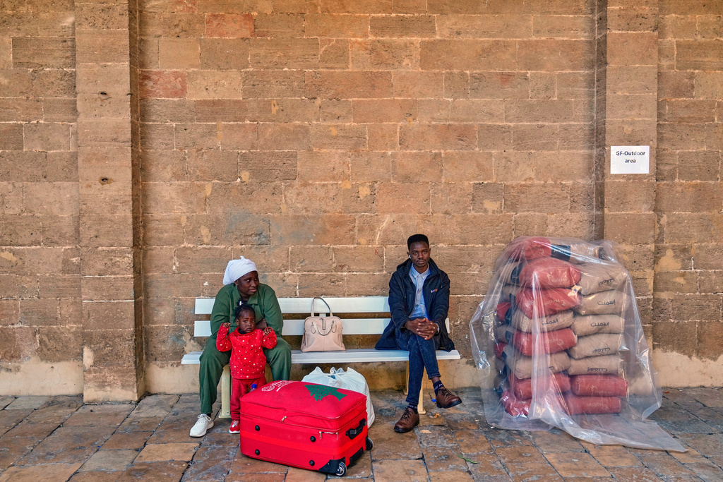 A displaced migrant family who among many others fled Israeli strikes in southern and eastern Lebanon and Beirut's southern suburbs wait to register at Saint Joseph Church, which has been turned into a shelter for displaced migrants, mostly from African nations, in Beirut, Wednesday, March 11, 2026. (AP Photo/Hussein Malla)