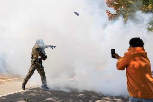 A government official throws a tear gas canister towards protesters in Chicago, Tuesday, Oct. 14, 2025. (Anthony Vazquez/Chicago Sun-Times via AP) A government official throws a tear gas canister towards protesters in Chicago, Tuesday, Oct. 14, 2025. (Anthony Vazquez/Chicago Sun-Times via AP)