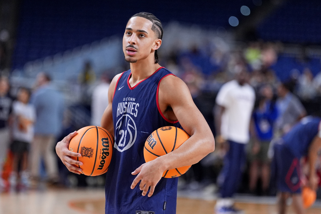 UConn's Jayden Ross holds two balls during practice ahead of a national semifinal NCAA college basketball tournament game against Illinois at the Final Four, Friday, April 3, 2026, in Indianapolis. (AP Photo/Michael Conroy)