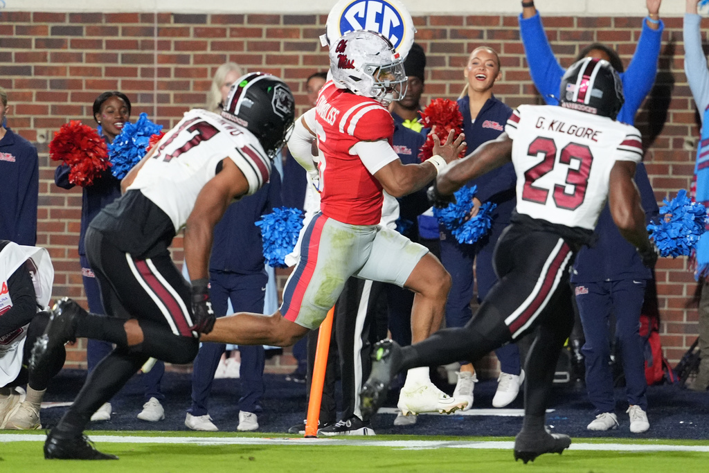 Mississippi quarterback Trinidad Chambliss (6) sprints past South Carolina linebacker Justin Okoronkwo (17) and defensive back Gerald Kilgore (23) for a 15-yard touchdown run during the first half of an NCAA college football game, Saturday, Nov. 1, 2025, in Oxford, Miss. (AP Photo/Rogelio V. Solis)