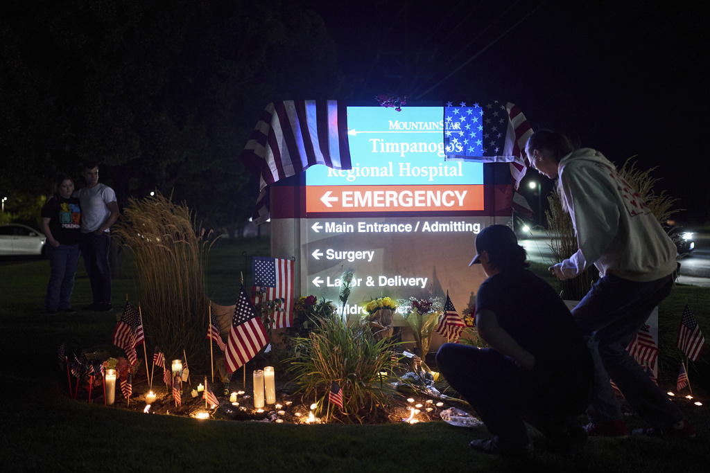 People visit a growing vigil for Charlie Kirk outside Timpanogos Regional Hospital after Kirk was shot and killed Wednesday, Sept. 10, 2025, in Orem, Utah. (AP Photo/Lindsey Wasson)