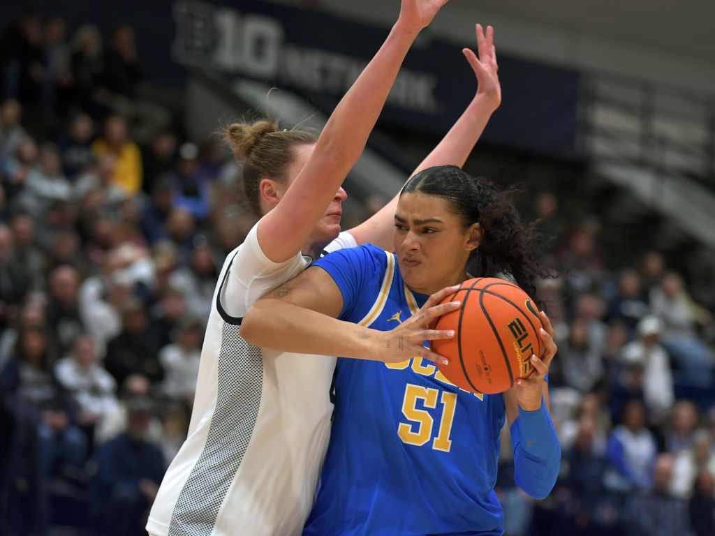 UCLA's Lauren Betts (51) goes to the basket on Penn State's Maggie Mendelson, left, during the first half of an NCAA college basketball game, Wednesday, Dec. 31, 2025, in State College, Pa. (AP Photo/Gary M. Baranec)