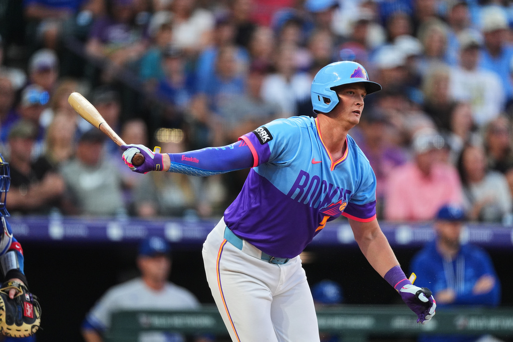 Colorado Rockies' TJ Rumfield follows the flight of his RBI single off Kansas City Royals starting pitcher Michael Wacha in the first inning of a baseball game Friday, July 31, 2026, in Denver. (AP Photo/David Zalubowski)