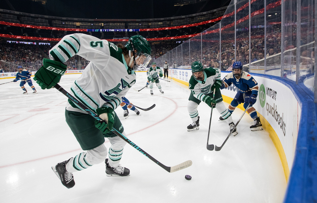 Boston Fleet's Megan Keller (5), Abby Newhook (19) and Vancouver Goldeneyes' Sydney Bard (11) battle for the puck during the first period of a PWHL hockey game in Edmonton on Tuesday, April 7, 2026. (Jason Franson/The Canadian Press via AP)