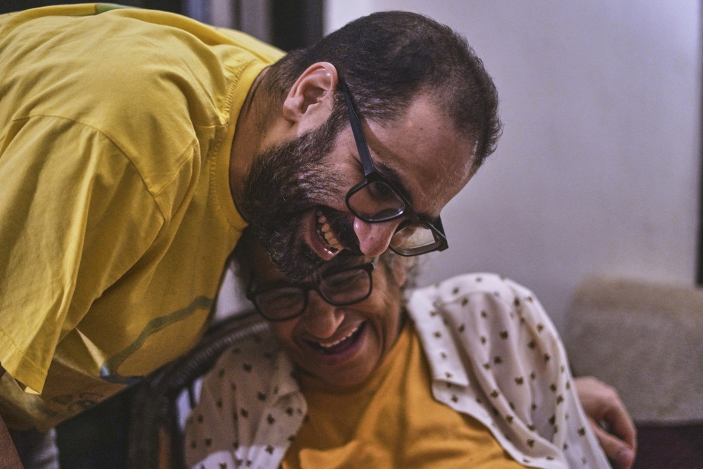 ADDS BACKGROUND OF THE ACTIVIST - Pro-democracy activist Alaa Abd el-Fattah, who was in prison for almost all of the past 12 years, hugs his mother Laila Soueif, as he arrives at his home, after a presidential pardon, in Cairo, Egypt, Tuesday, Sept. 23, 2025. (AP Photo/Amr Nabil)