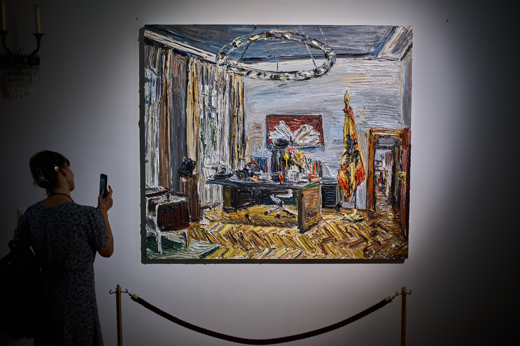 A person takes a photo of the painting "Im Buero des Bundespraesidenten" (In the office of the Federal President), by Christopher Lehmpfuhl, during the press preview of an exhibition of contemporary art at the German President's residency, Bellevue Palace, in Berlin, Germany, Monday, June 8, 2026. (AP Photo/Markus Schreiber)