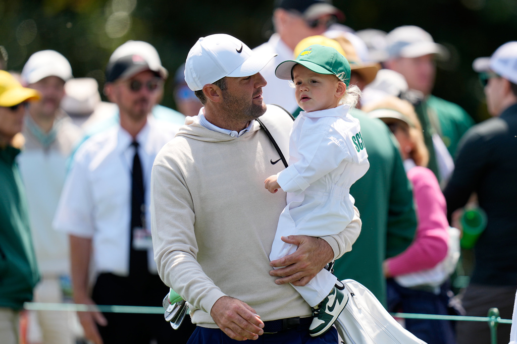Scottie Scheffler, left, carries his son, Bennett, on the sixth hole during par-3 contest ahead of the Masters golf tournament at the Augusta National Golf Club, Wednesday, April 8, 2026, in Augusta, Ga. (AP Photo/Eric Gay)