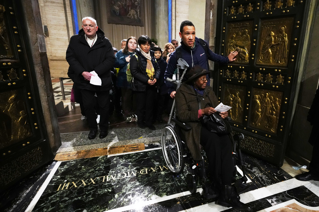 Natalie Turner and her son Phillip cross the Holy Door in St.Peter's Basilica at the Vatican on the last day of its public opening, Monday, Jan. 5, 2026. (AP Photo/Alessandra Tarantino)
