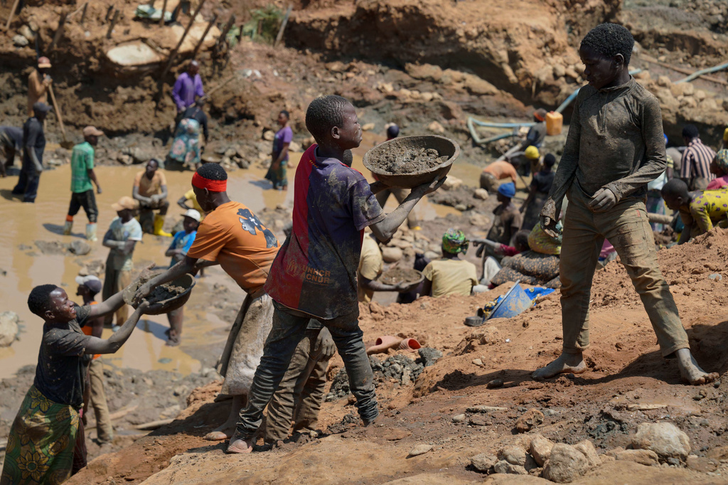 Adults and children search for gold at a mining site in Iga-Barrière, Ituri province, eastern Congo, Friday, Aug. 14, 2026. (AP Photo/Dieudonne Dirole)