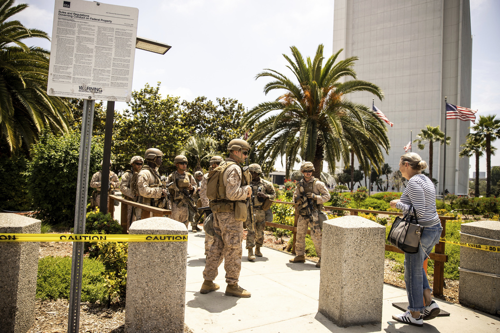 FILE - Members of the California National Guard and U.S. Marines, guard the entrance outside the Wilshire Federal in Los Angeles, June 13, 2025. (Stephen Lam/San Francisco Chronicle via AP, File)