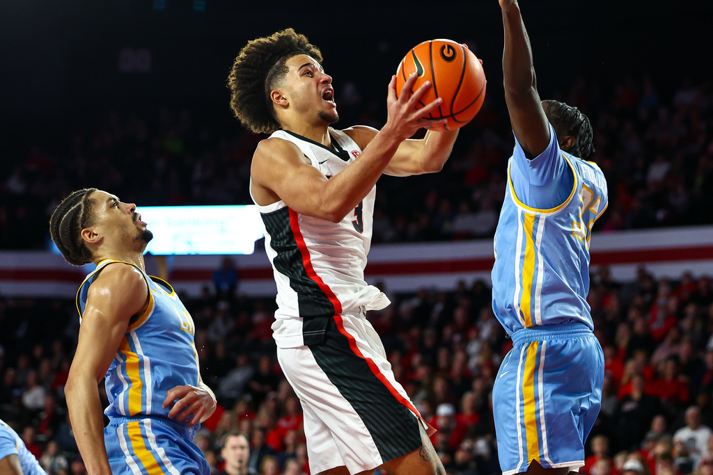 Georgia guard Jordan Ross, center, shoots against LIU Brooklyn forward Jamal Fuller, right, during the first half of an NCAA college basketball game Monday, Dec. 29, 2025, in Athens, Ga. (AP Photo/Colin Hubbard)