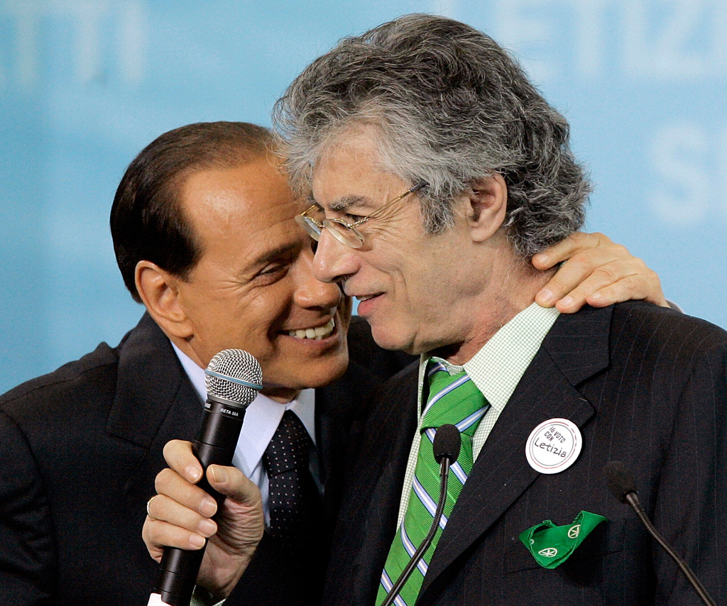 Northern League leader Umberto Bossi is embraced by Italian premier Silvio Berlusconi, left, at a rally to support the candidature of Letizia Moratti to mayor of Milan, in this northern Italian city, May 7, 2006. Bossi died at the age of 84 on Thursday, March 19, 2026. (AP Photo/Antonio Calanni, File)