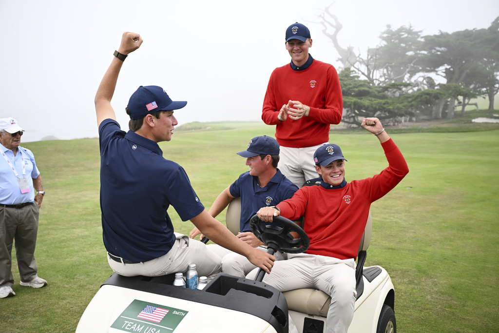 Members of the USA team celebrate on the 17th hole after winning the Walker Cup golf tournament over the Great Britain and Ireland team at Cypress Point Club on Sunday, Sept. 7, 2025, in Pebble Beach, Calif. (AP Photo/Thien-An Truong )
