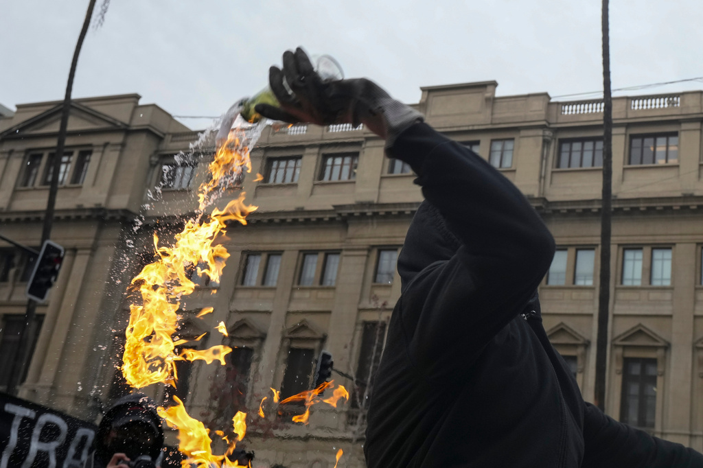 A student throws a Molotov cocktail at police during a protest against the government's proposal to lower the education budget, in Santiago, Chile, Wednesday, June 3, 2026. (AP Photo/Esteban Felix)