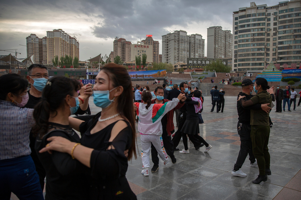 FILE - People dance to music at a public square in Aksu in western China's Xinjiang Uyghur Autonomous Region, as seen during a government organized trip for foreign journalists, April 20, 2021. (AP Photo/Mark Schiefelbein, File)