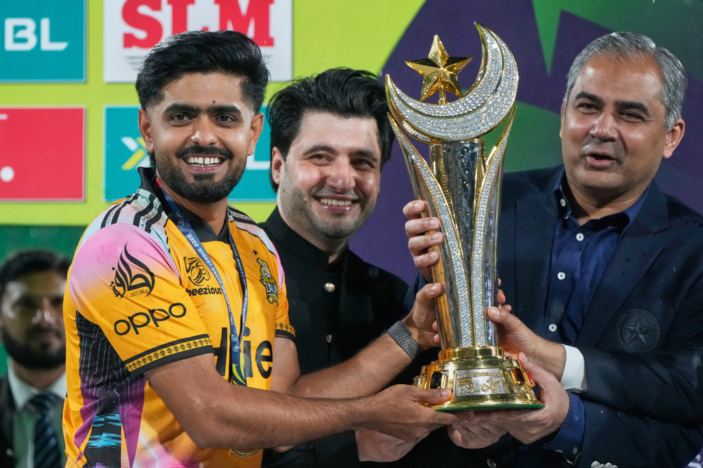Peshawar Zalmi's skipper Babar Azam, left, receives winning trophy from Pakistan's Interior Minister and Chairman of Pakistan Cricket Board Mohsin Naqvi on the of the Pakistan Super League final cricket match against Hyderabad Kingsmen, in Lahore, Pakistan, Monday, May 4, 2026. (AP Photo/K.M. Chaudary)