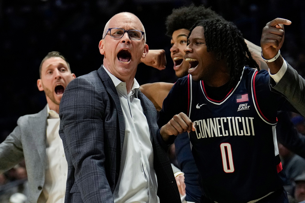UConn head coach Dan Hurley, left, and guard Malachi Smith (0) celebrate during the second half of an NCAA college basketball game against Xavier, Wednesday, Dec. 31, 2025, in Cincinnati. (AP Photo/Carolyn Kaster)