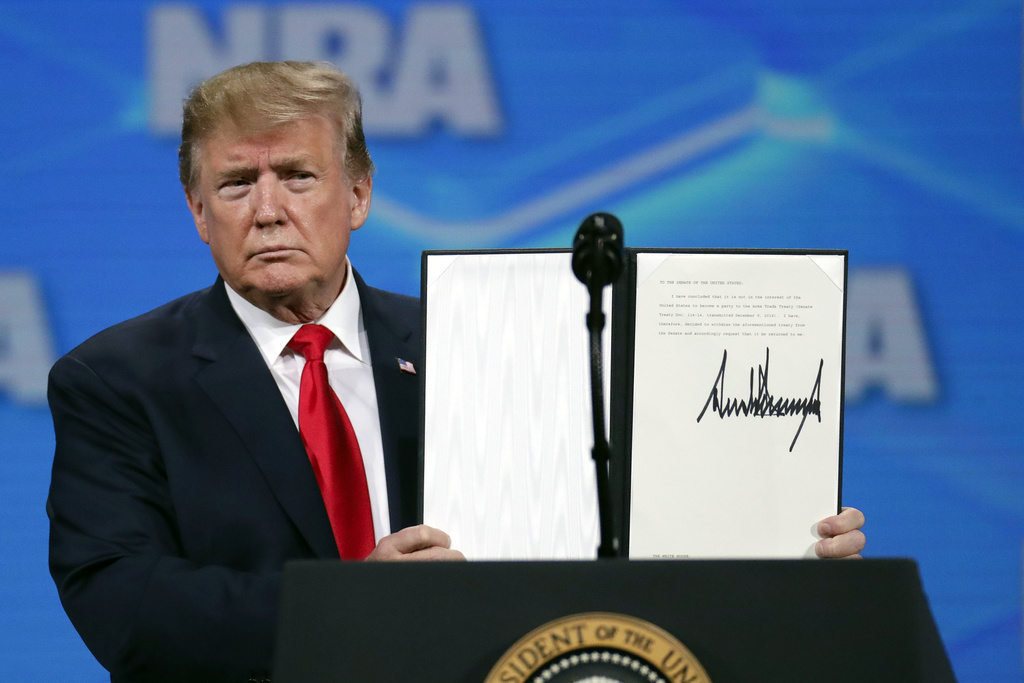 FILE - President Donald Trump holds a document with his signature as he speaks at the Nation Rifle Association Institute for Legislative Action Leadership Forum in Lucas Oil Stadium in Indianapolis, Friday, April 26, 2019. (AP Photo/Michael Conroy, File)