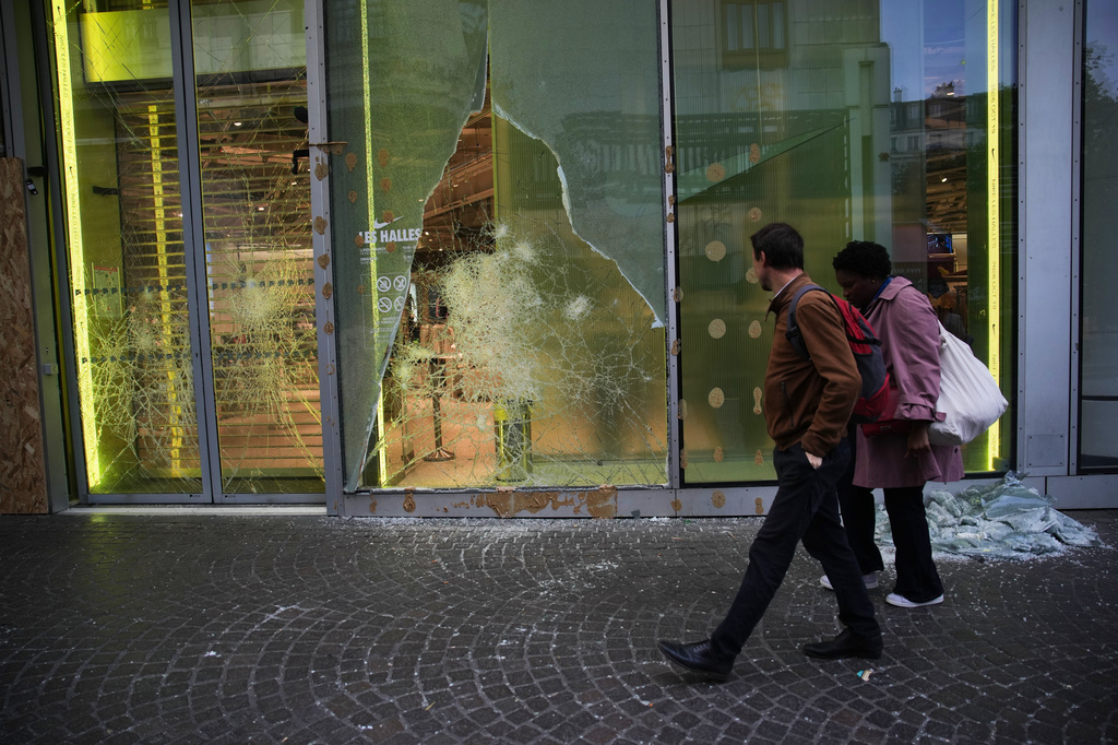 People walk past a looted store, after violence erupted during nationwide protests against rising living costs and poor conditions in schools, in Paris, Monday, Oct. 19, 2026. (AP Photo/Christophe Ena)