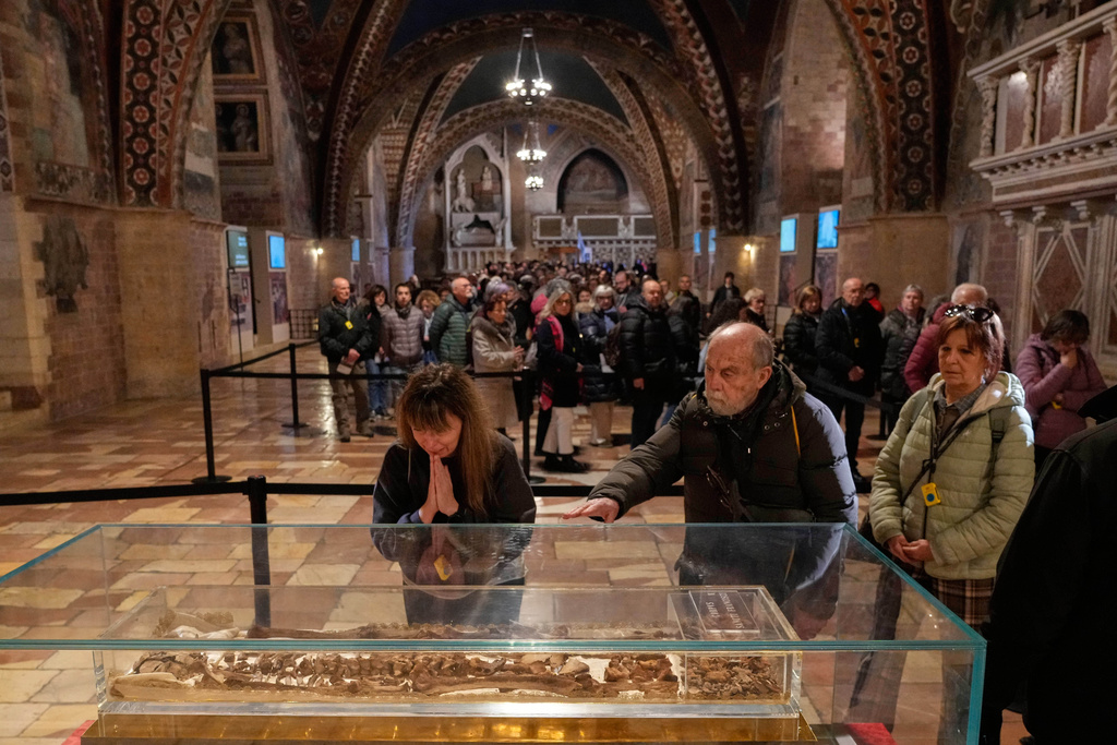 Pilgrims honor the bones of St. Francis during the first public display inside the St. Francis Basilica, marking the 800th anniversary of the saint death, in Assisi, Italy, Sunday, Feb. 22, 2026.(AP Photo/Gregorio Borgia)